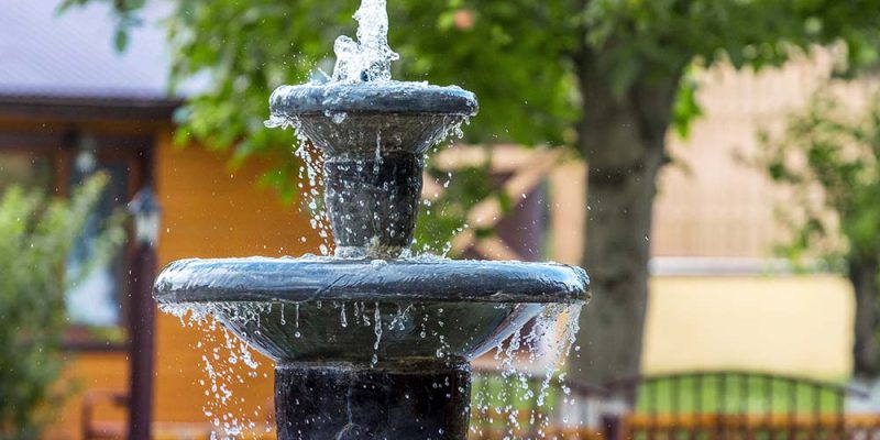 Fountain in the city park. Flow of water flows from the fountain