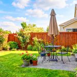 Landscaped residential backyard with patio furniture and wooden privacy fence