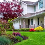 Landscaped front yard with flowering shrubs and manicured green lawn